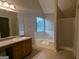 Bathroom featuring a large soaking tub, a separate shower, and a vanity with countertop space at 705 Mustang Ct, Hampton, GA 30228
