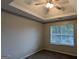 Bedroom featuring tray ceiling, neutral walls and ceiling fan at 705 Mustang Ct, Hampton, GA 30228