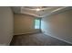 Bedroom with a ceiling fan, neutral carpet, a window for natural light, and tray ceilings at 705 Mustang Ct, Hampton, GA 30228