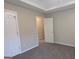 Neutral bedroom featuring plush carpeting, tray ceilings, and an ensuite bathroom at 705 Mustang Ct, Hampton, GA 30228