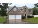 Traditional brick house with an attached two-car garage and a well-manicured lawn at 705 Mustang Ct, Hampton, GA 30228