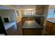 Open concept kitchen with an island and dark countertops flowing into the dining room at 705 Mustang Ct, Hampton, GA 30228