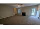 Open-concept living room features a fireplace, ceiling fan, neutral color palette and stairs at 705 Mustang Ct, Hampton, GA 30228