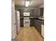 Functional kitchen with gray cabinetry, modern white appliances, and vinyl flooring at 755 Magnolia Gardens Walk, Mcdonough, GA 30253