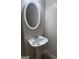Stylish powder room with pedestal sink and oval mirror at 755 Magnolia Gardens Walk, Mcdonough, GA 30253