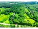 Stunning aerial view of estate nestled within lush green forest with long driveway at 301 East Highway 5, Roopville, GA 30170