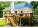 The backyard features a large deck, wood railings and stairs down to a covered patio area at 301 East Highway 5, Roopville, GA 30170