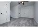 An empty bedroom with gray carpeting, three white paneled doors, a ceiling fan and neutral-toned walls at 301 East Highway 5, Roopville, GA 30170