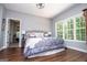 Bedroom with hardwood floors, large windows, ceiling fan, and adjacent bathroom, creating a serene space at 301 East Highway 5, Roopville, GA 30170