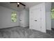 Bedroom with gray carpet, ceiling fan, two white doors with black knobs, and a window at 301 East Highway 5, Roopville, GA 30170