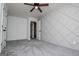 Bedroom featuring gray carpet, modern ceiling fan and an accent wall with geometric trim at 301 East Highway 5, Roopville, GA 30170