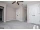 Bedroom with a gray color scheme, ceiling fan, gray carpeting, and a double-door closet at 301 East Highway 5, Roopville, GA 30170