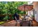 The spacious wooden deck includes a dining set with an umbrella, a grill, and ample space for outdoor entertaining at 301 East Highway 5, Roopville, GA 30170
