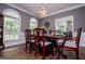 Elegant dining room with an ornate chandelier, natural light, and dark wood flooring at 301 East Highway 5, Roopville, GA 30170