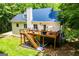 Exterior of the home showcasing a spacious deck, stairs leading down to the yard, and beautiful landscaping at 301 East Highway 5, Roopville, GA 30170