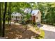 Scenic home featuring a covered front porch, brick accents, an attached garage, and mature trees at 301 East Highway 5, Roopville, GA 30170