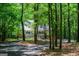 View of a home with a white porch and metal roof through the trees at 301 East Highway 5, Roopville, GA 30170