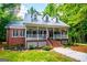 Beautiful two-story home with a metal roof, dormer windows, and inviting front porch with brick stairs at 301 East Highway 5, Roopville, GA 30170