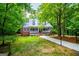 Quaint home with a metal roof, a welcoming front porch, and surrounded by lush greenery and mature trees at 301 East Highway 5, Roopville, GA 30170