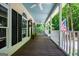 Inviting front porch with a wooden floor, white columns, ceiling fans, and views of the surrounding greenery at 301 East Highway 5, Roopville, GA 30170