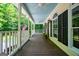 Spacious front porch with wood flooring, black shutters, and an American flag creating a cozy outdoor space at 301 East Highway 5, Roopville, GA 30170