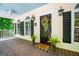 Welcoming front porch featuring a dark wood door, stylish light fixtures, potted plants, and a 'Welcome' mat at 301 East Highway 5, Roopville, GA 30170