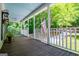 Charming front porch featuring a wooden floor, ceiling fans, and white railings, perfect for relaxing outdoors at 301 East Highway 5, Roopville, GA 30170