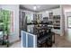 Bright, open kitchen with central island with seating, stainless appliances, and large windows at 301 East Highway 5, Roopville, GA 30170