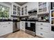 Well-lit kitchen features white cabinets, granite countertops, stainless appliances, and a stylish backsplash at 301 East Highway 5, Roopville, GA 30170