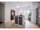 Bright, open kitchen with central island with seating, stainless appliances, and large windows at 301 East Highway 5, Roopville, GA 30170