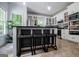 Bright, open kitchen with central island with seating, stainless appliances, and large windows at 301 East Highway 5, Roopville, GA 30170