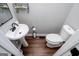 Cozy powder room featuring wood floors, pedestal sink, and toilet at 301 East Highway 5, Roopville, GA 30170