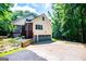 Home with an attached garage featuring a daylight basement, complemented by a lush, wooded surrounding at 301 East Highway 5, Roopville, GA 30170
