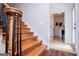 A well-lit staircase with wooden steps and black metal balusters, leading to the upper level and laundry room at 301 East Highway 5, Roopville, GA 30170