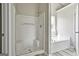 Bright bathroom featuring glass enclosed shower and separate soaking tub by a sunny window at 1255 Silverstone Trl, Jonesboro, GA 30238