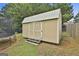 Backyard shows a beige shed with gray roofing, next to a trampoline in a well-maintained lawn at 1255 Silverstone Trl, Jonesboro, GA 30238