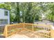 New wooden deck with railing offers serene views of the lush, green backyard at 1446 Westmont Sw Rd, Atlanta, GA 30311