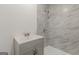 Bathroom featuring a vanity and shower with marble wall tiles at 1446 Westmont Sw Rd, Atlanta, GA 30311
