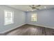This light-blue bedroom features wood-look floors, a ceiling fan, and natural light through windows at 1446 Westmont Sw Rd, Atlanta, GA 30311