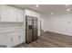 White kitchen cabinets with stainless steel fridge and hardwood floors at 1446 Westmont Sw Rd, Atlanta, GA 30311
