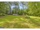 Backyard with a storage shed, raised garden beds, beautiful green grass and plentiful shade trees at 2164 Old Rex Morrow Rd, Morrow, GA 30260