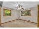 Neutral bedroom featuring two windows, a ceiling fan, and plush carpeting at 2164 Old Rex Morrow Rd, Morrow, GA 30260
