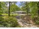 Long driveway leading to a bright home surrounded by lush greenery and mature trees on a sunny day at 2164 Old Rex Morrow Rd, Morrow, GA 30260