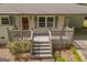Charming home entrance with wooden porch and brick facade, accented by blooming plants at 2164 Old Rex Morrow Rd, Morrow, GA 30260