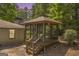 Enclosed gazebo adjacent to brick house and green lawn offering a private outdoor space at 2164 Old Rex Morrow Rd, Morrow, GA 30260