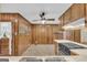 Eat-in kitchen features wood paneling, ceiling fan, and range with marble countertop overlooking stainless sink at 2164 Old Rex Morrow Rd, Morrow, GA 30260