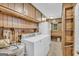 The utility room has both a washer and dryer along with wood shelving and a white refrigerator at 2164 Old Rex Morrow Rd, Morrow, GA 30260