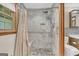 Beautiful, tiled shower with rainfall shower head, built-in bench, and pebble flooring at 2164 Old Rex Morrow Rd, Morrow, GA 30260
