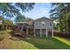 Large backyard view of raised wood deck with staircase surrounded by lush green foliage at 3859 N Camp Creek Sw Pkwy, Atlanta, GA 30331