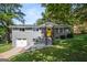Charming gray brick home with a bright yellow front door, surrounded by a lush, green, landscaped yard at 3859 N Camp Creek Sw Pkwy, Atlanta, GA 30331
